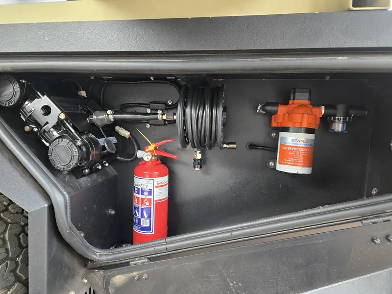 Air compressor, plumbing and fire extinguisher in a canopy